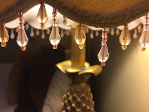 A lamp with a textured lampshade and hanging crystal beads.