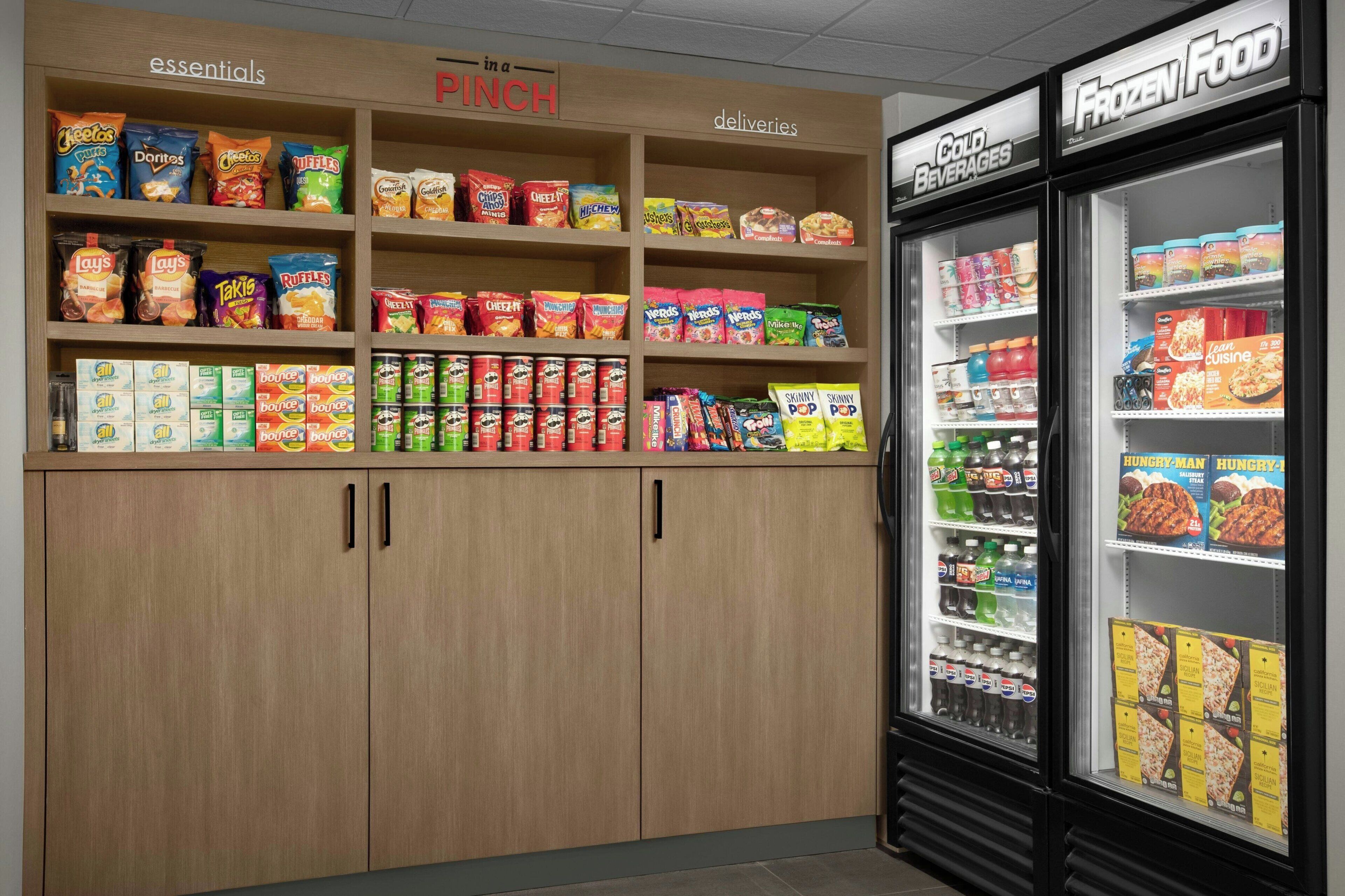 A snack and frozen food section in a store with various brands and types of snacks, including chips and dried fruits.