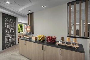 Una cocina moderna con barra desayunadora, armarios de madera y un cartel de pizarra.