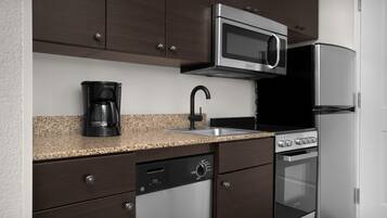 Una cocina equipada con microondas, cafetera, lavavajillas, horno y refrigerador.