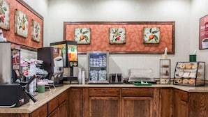 A coffee station with a coffee machine, a beverage dispenser, and a refrigerated display. - Econo Lodge Lake Region (West Ossipee)