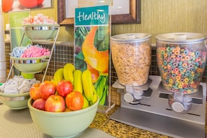 Un bufé de desayuno con frutas frescas, cereales y aperitivos.