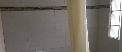 A small bathroom with a toilet, a bathtub, and a shower curtain.