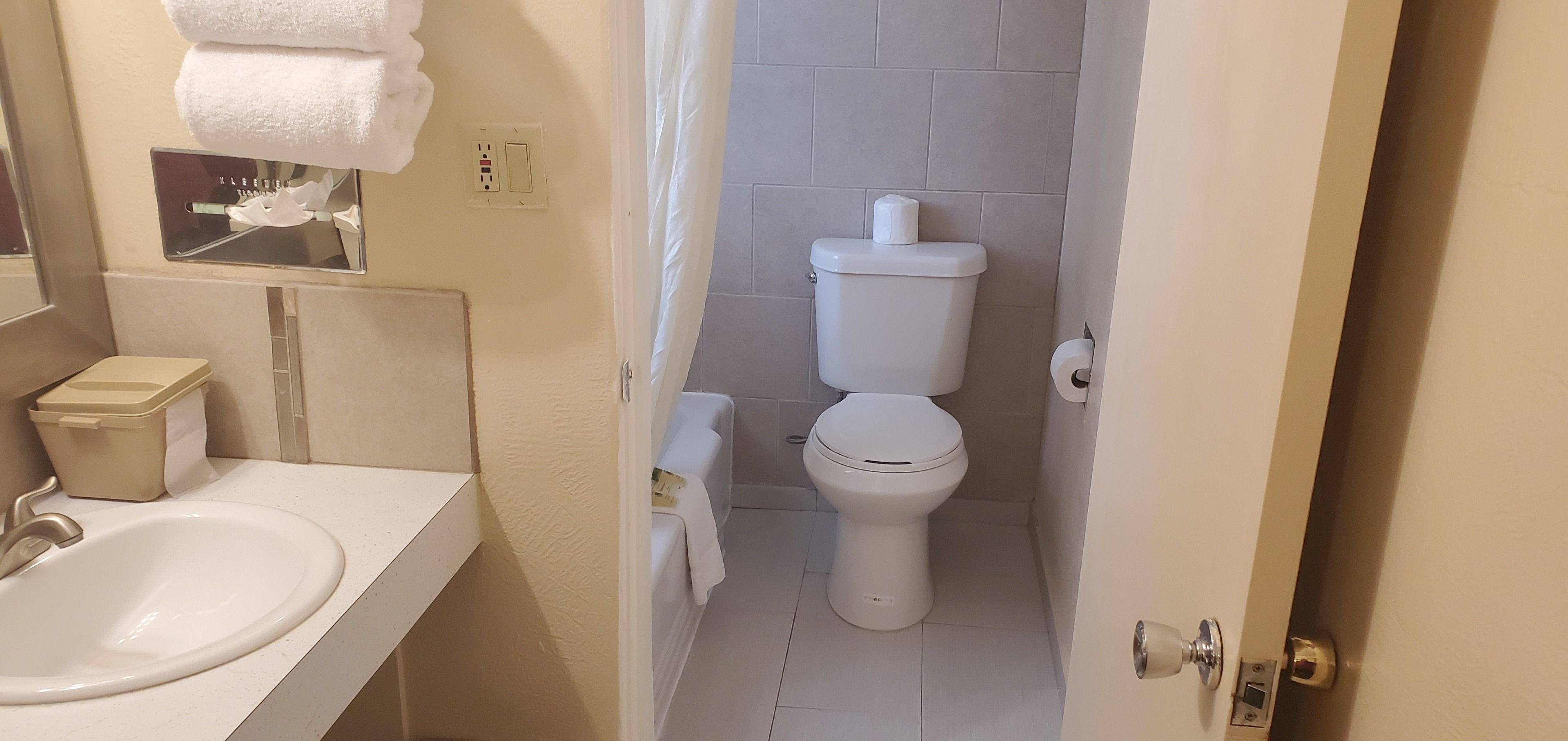 A bathroom with a sink, toilet, and a towel rack.