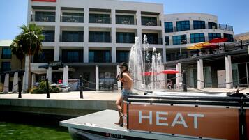 A boat docked at a waterfront with a building labeled "HEAT" in the background.