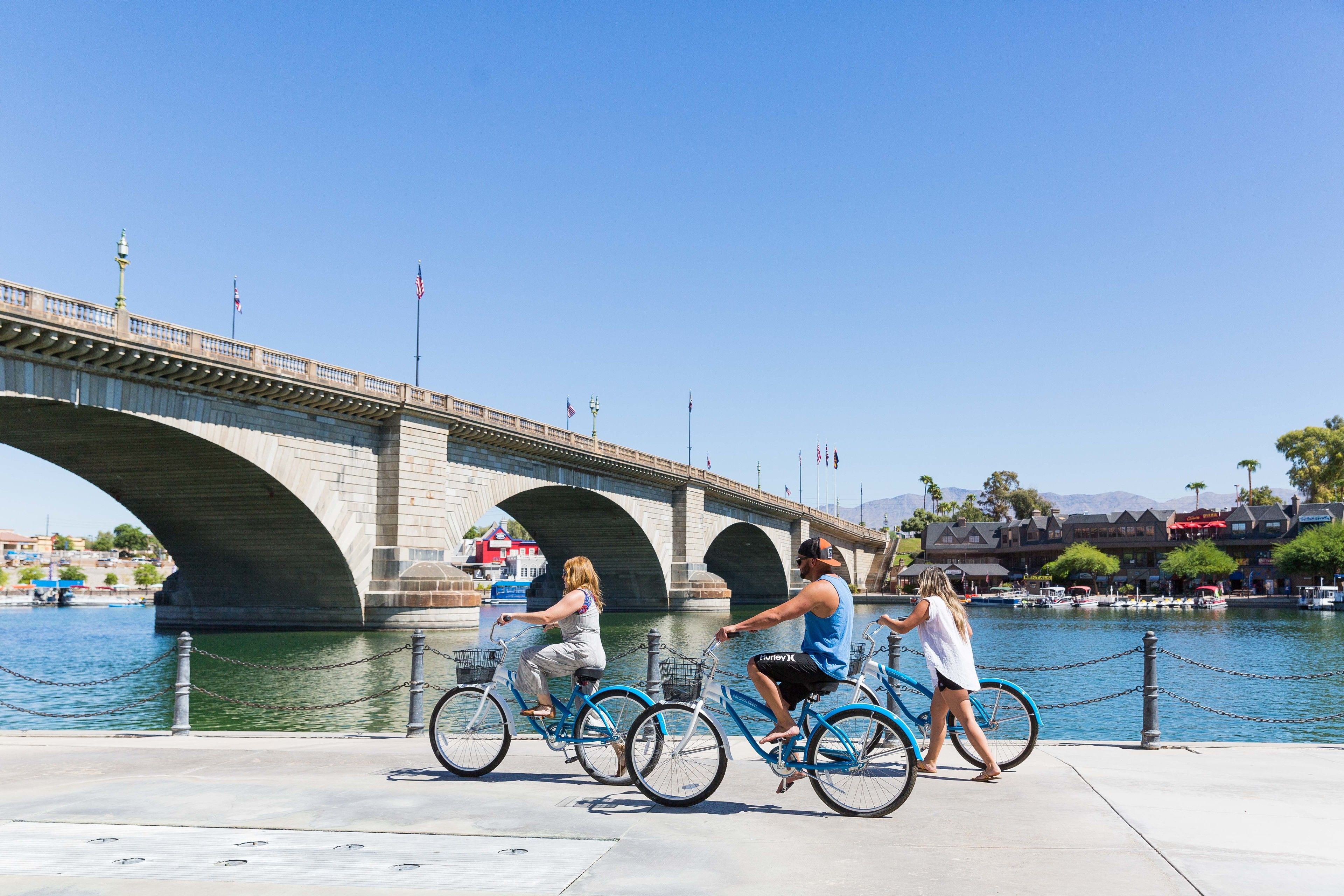 A bridge with a chain barrier and people riding bicycles.