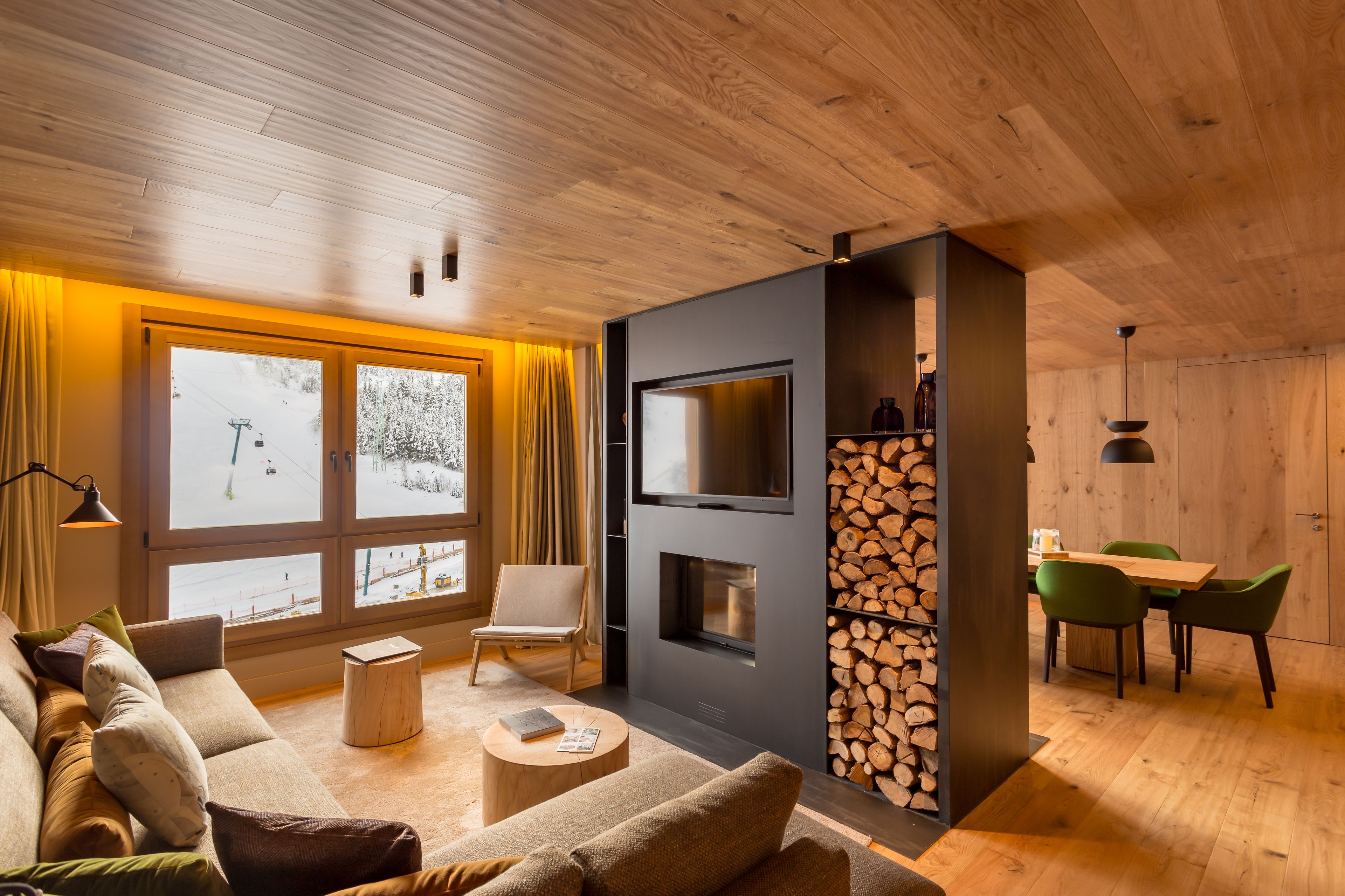 Una sala de estar moderna con un ventanal grande, chimenea, televisor y comedor.