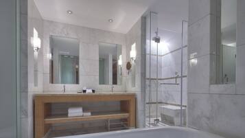 Une salle de bain moderne avec une grande baignoire, un meuble-lavabo en bois et une douche séparée par des parois de verre.