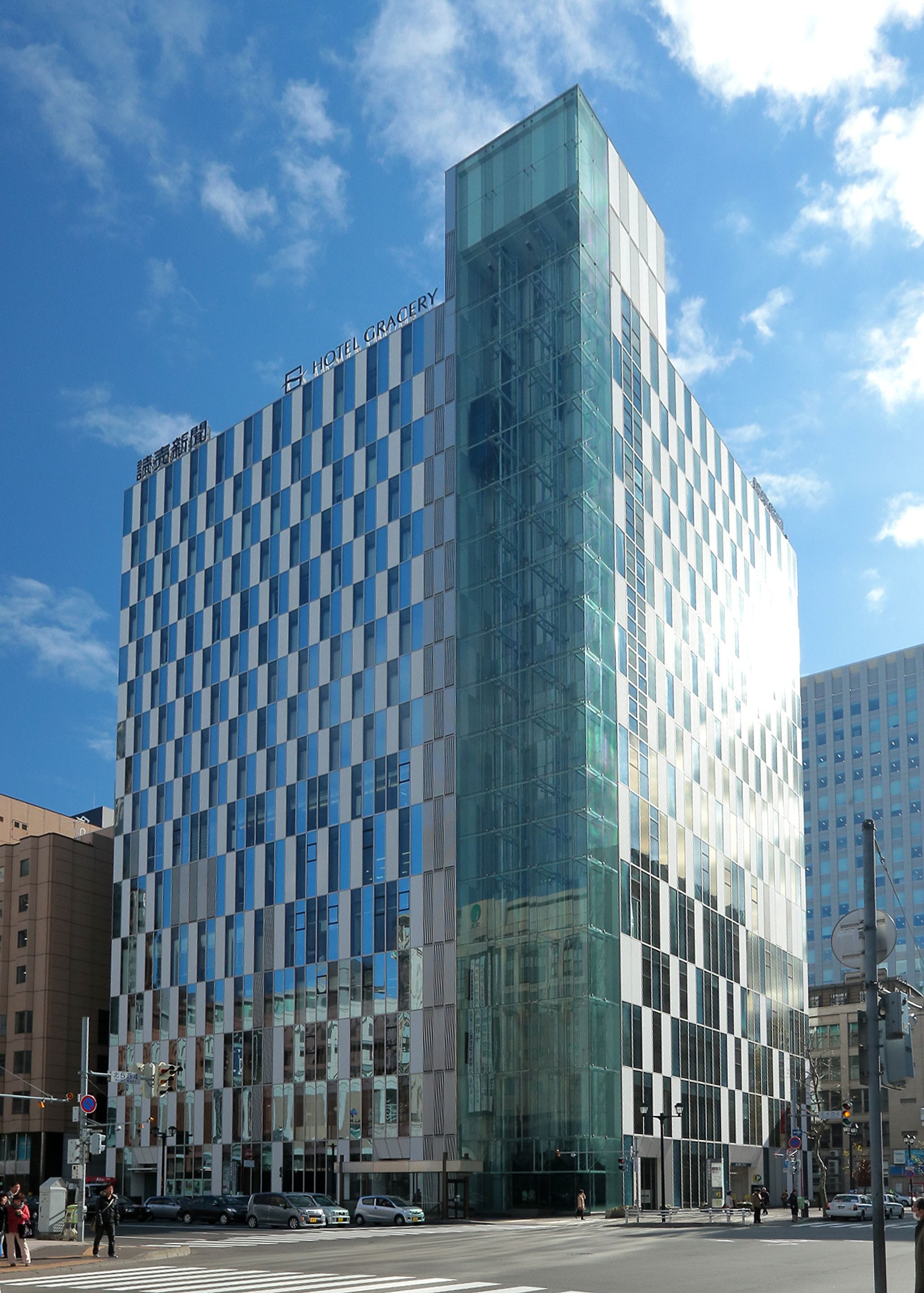 A modern hotel with a glass facade and a checkered pattern of windows.