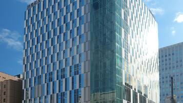 A modern hotel with a glass facade and a checkered pattern of windows.