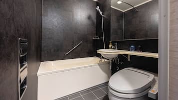 A modern bathroom with a bathtub, toilet, and sink.