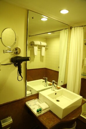 A bathroom with two sinks, a hairdryer, a mirror, and a towel rack. - Kences, Tirupati (Tirupati)