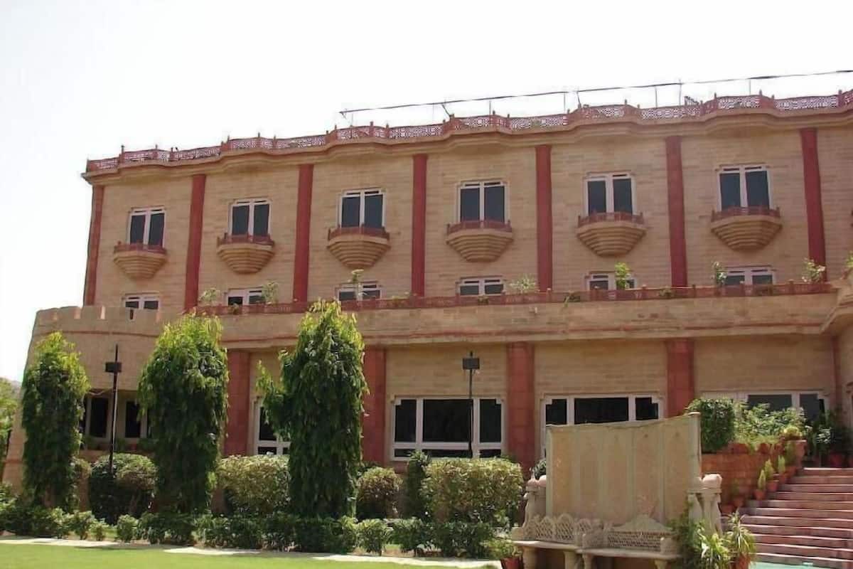Un edificio de varios pisos con fachada simétrica, ventanas amplias y una escalera central.