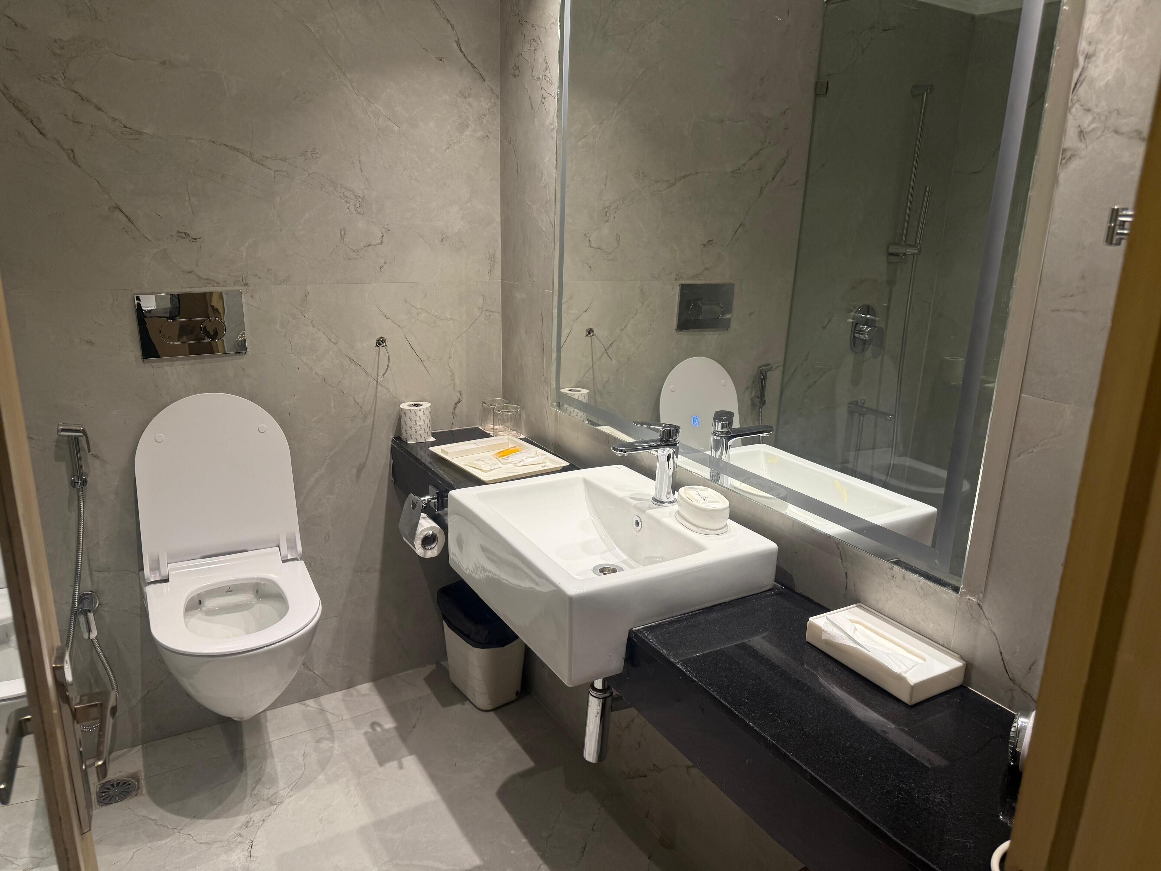A modern bathroom with a toilet, sink, and shower.