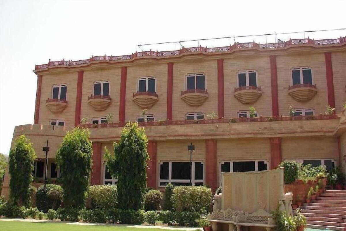 Un edificio de varios pisos con fachada simétrica, ventanas amplias y una escalera central.