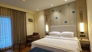 Una habitación de hotel moderna con una cama grande, mesitas de noche, un escritorio y una silla.