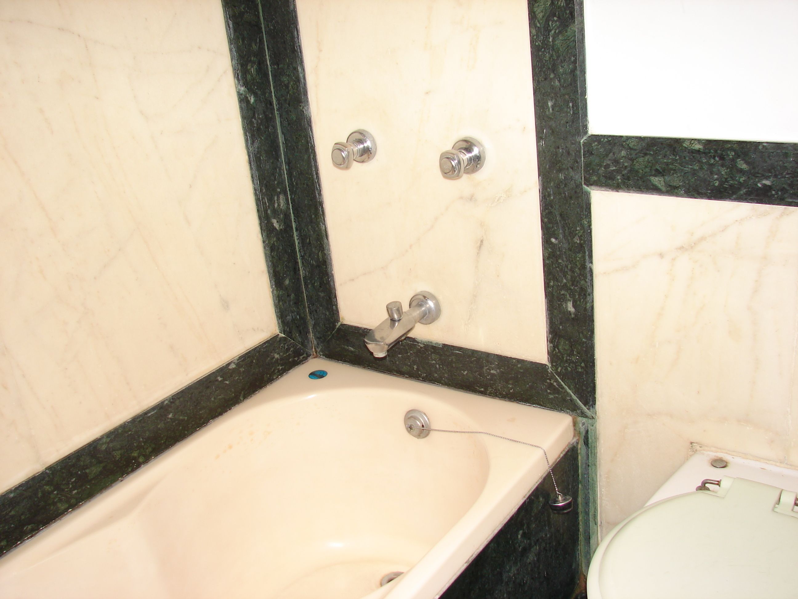 Un baño con un lavamanos blanco, un espejo y un inodoro.