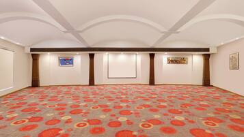 Una habitación amplia con alfombra estampada, iluminación empotrada y obras de arte en las paredes.