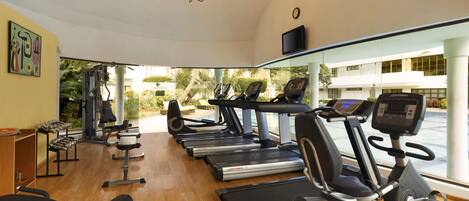 A gym with treadmills, stationary bikes, and weight machines.