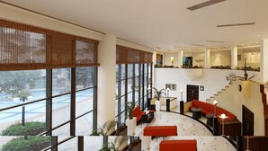 A spacious lobby with a high ceiling, a staircase, and seating areas. - Lemon Tree Hotel, Aurangabad (Chhatrapati Sambhajinagar)