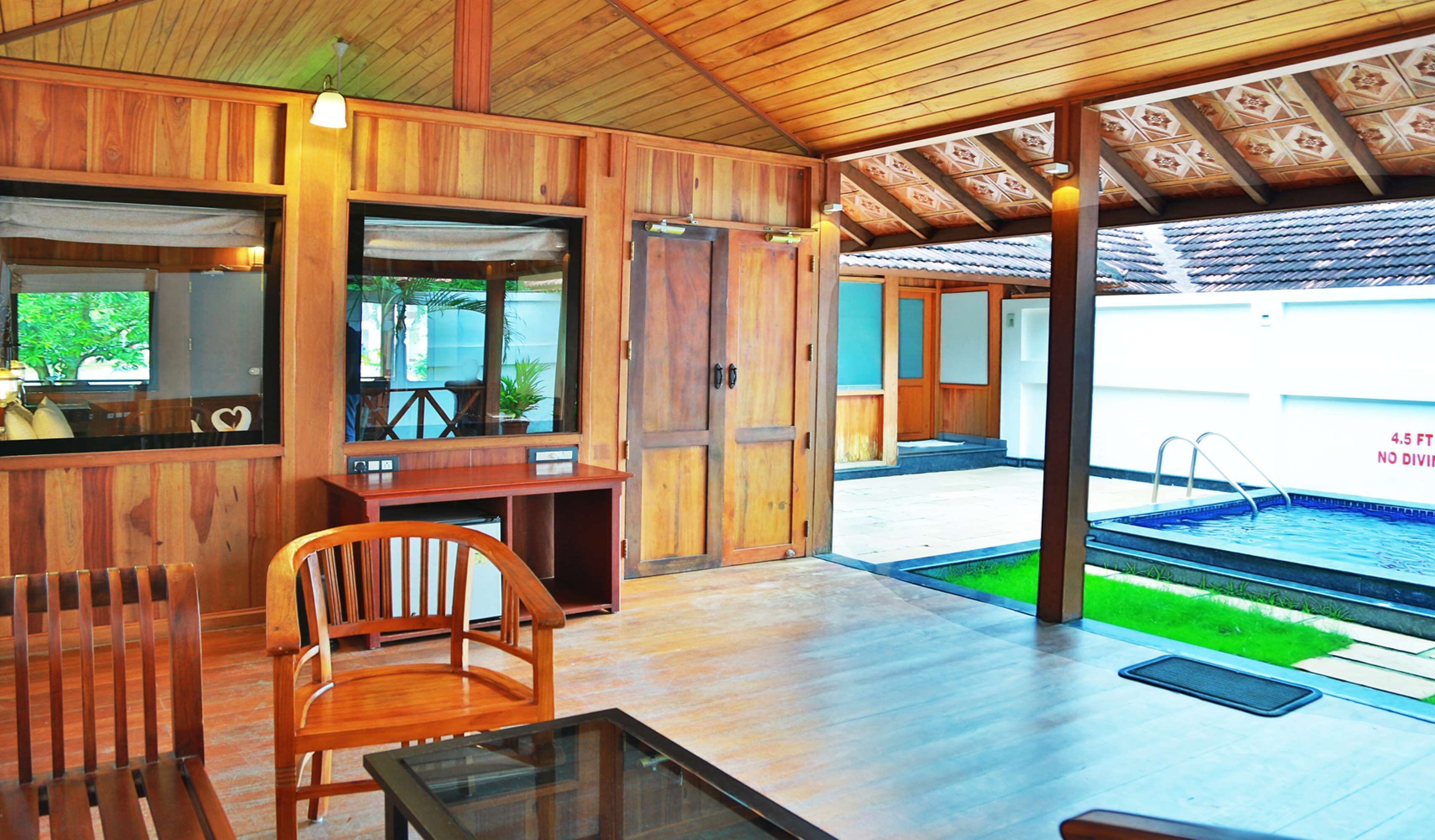 A wooden interior with a pool visible through an open door.