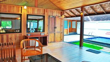 A wooden interior with a pool visible through an open door.