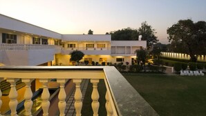Un hotel moderno con un patio, piscina y césped bien cuidado.