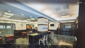 Un hall de hotel con una recepción, zona de estar y un amplio ventanal.