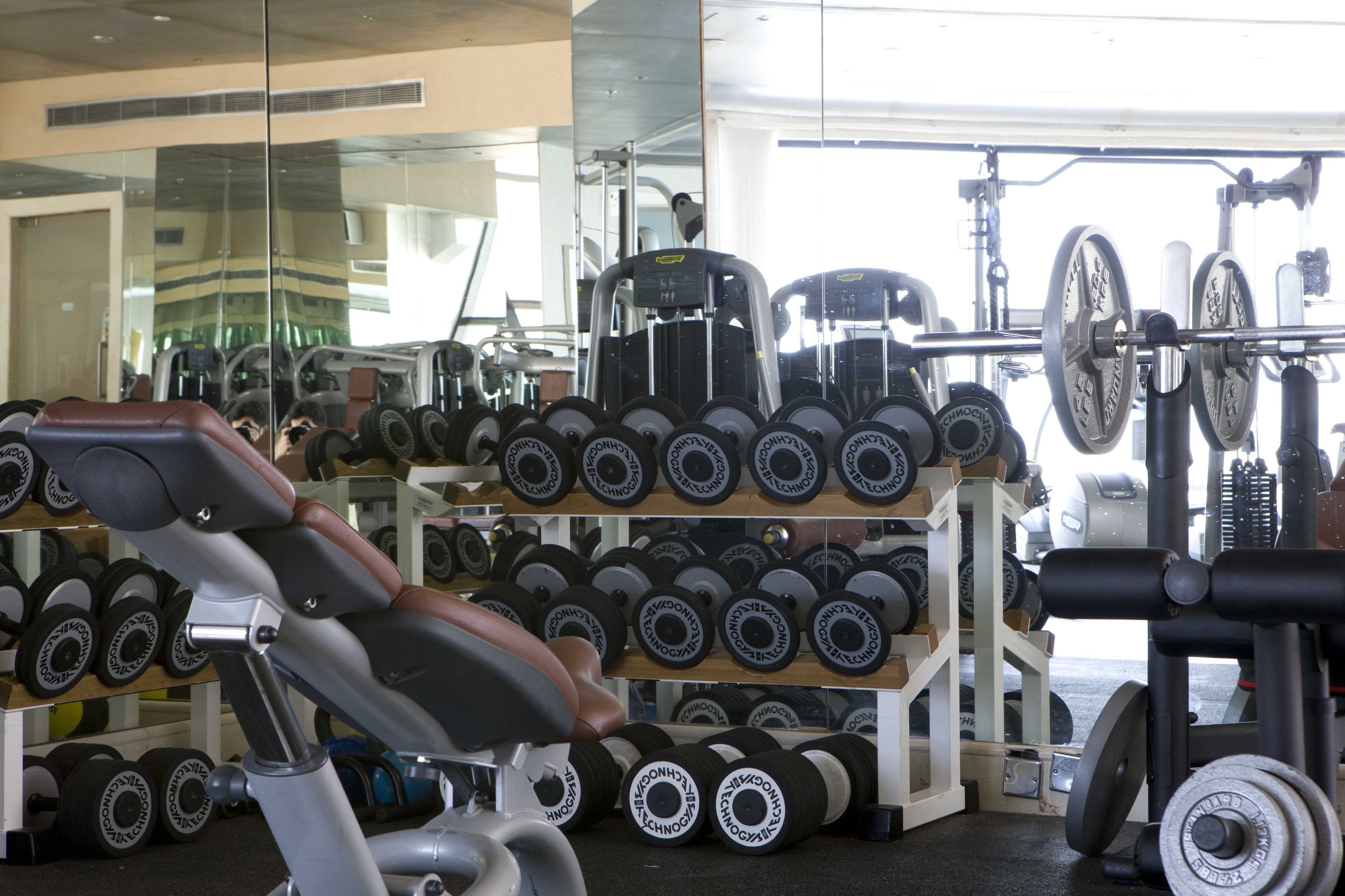 Un gimnasio con equipo de ejercicio, incluyendo pesas y un banco.