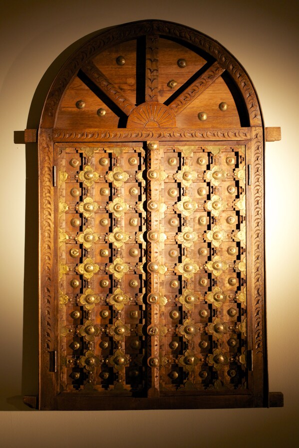 A wooden door with intricate carvings and brass fixtures.