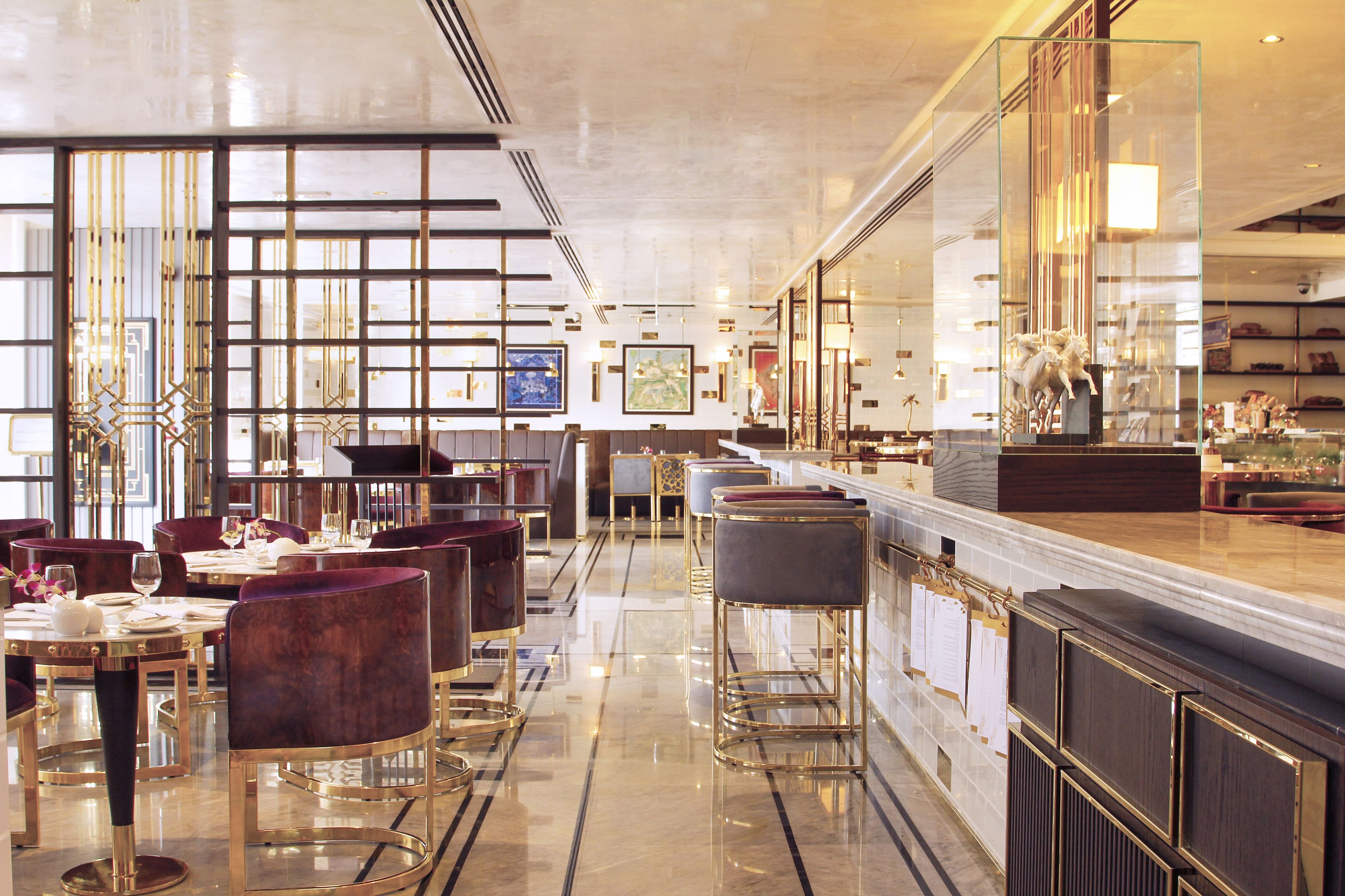 Un restaurant moderne, avec un décor élégant, des meubles haut de gamme, un sol en marbre poli et un espace bar.