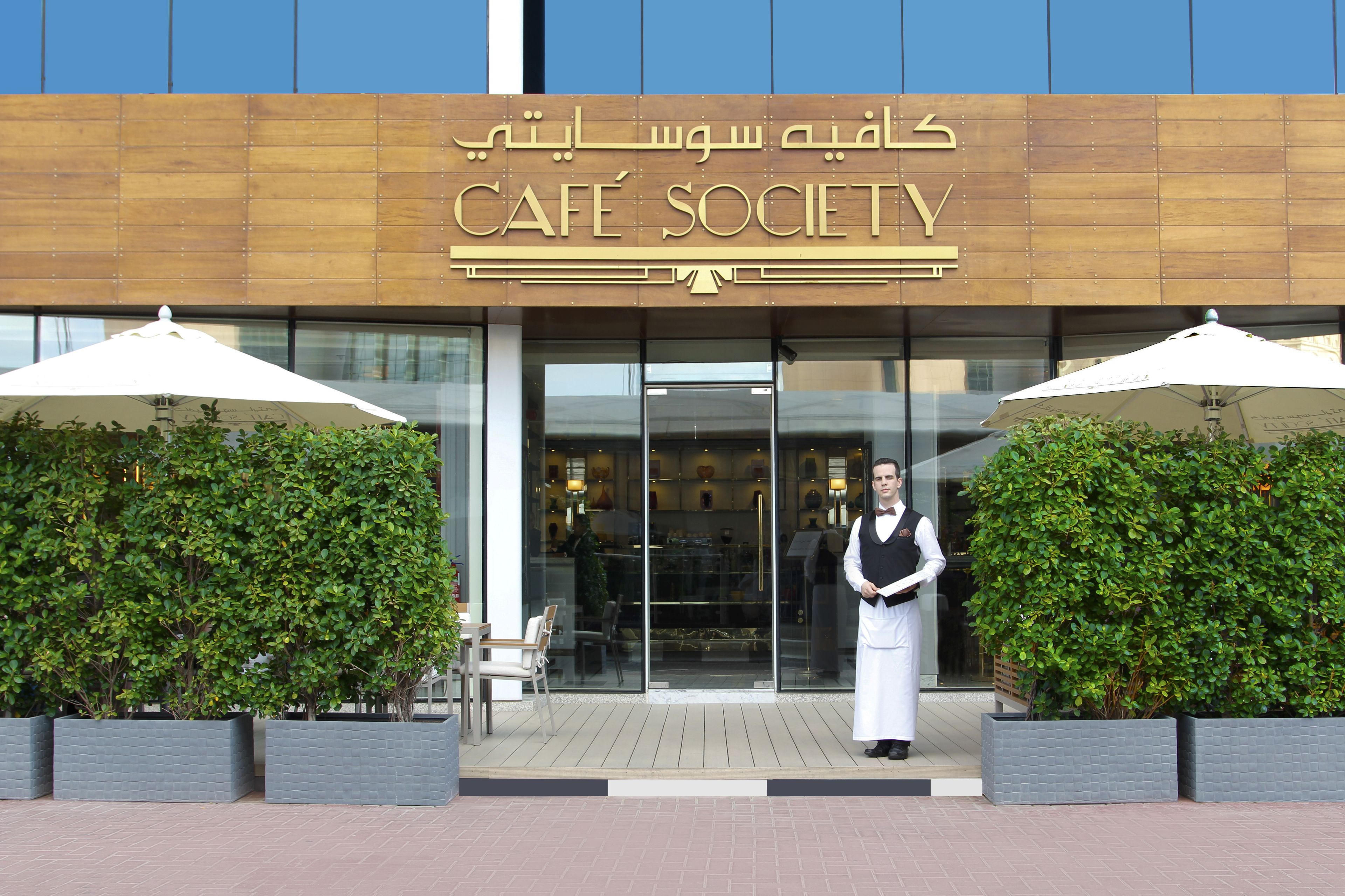 A building with a sign reading "CAFE SOCIETY" and a person standing in front.