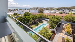 Área residencial com piscina, vegetação e edifícios ao fundo.