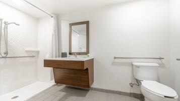 Un baño moderno con ducha, inodoro y tocador.