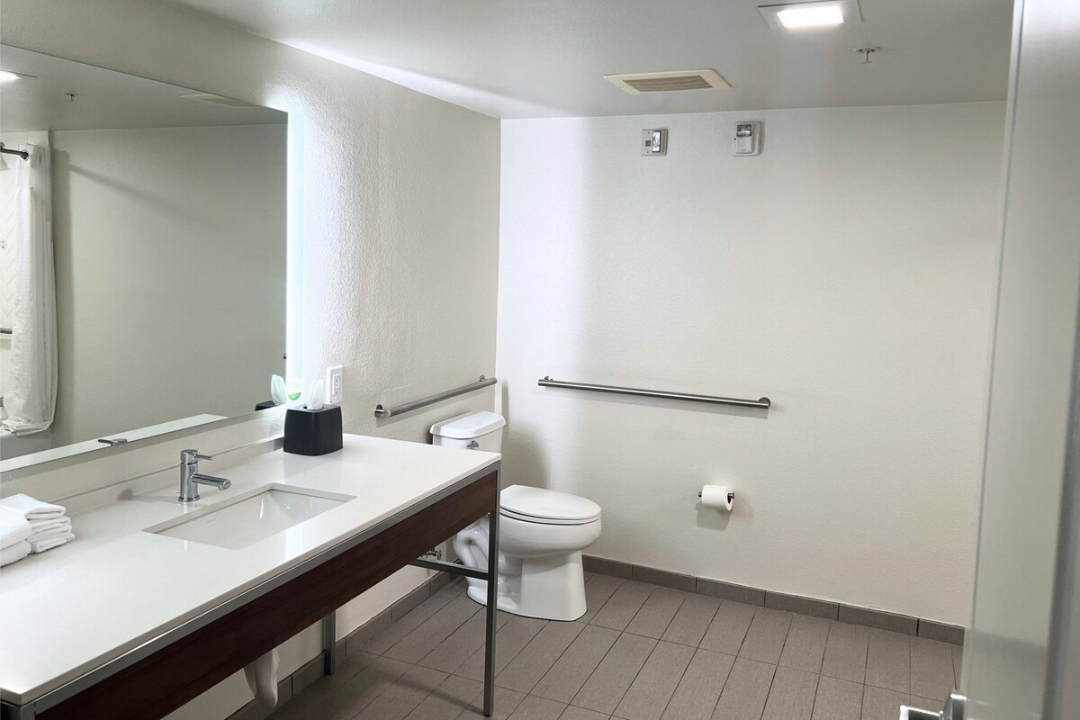 Een moderne badkamer met een wit wastafelmeubel, spiegel en toilet.