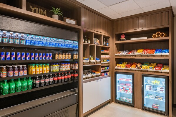 Een overzichtelijk gedeelte met drankjes en snacks, met diverse merken en soorten dranken, waaronder frisdranken en vruchtensappen, en een assortiment aan snacks en verpakte producten.