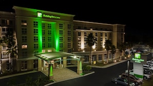 A Holiday Inn & Suites hotel with a covered entrance, multiple floors, and a parking lot.