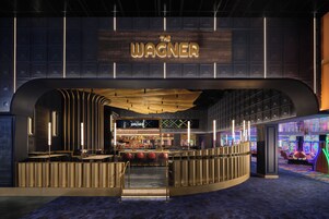 Zona de bar con un letrero que dice 'The Wagner' y una barra con taburetes.