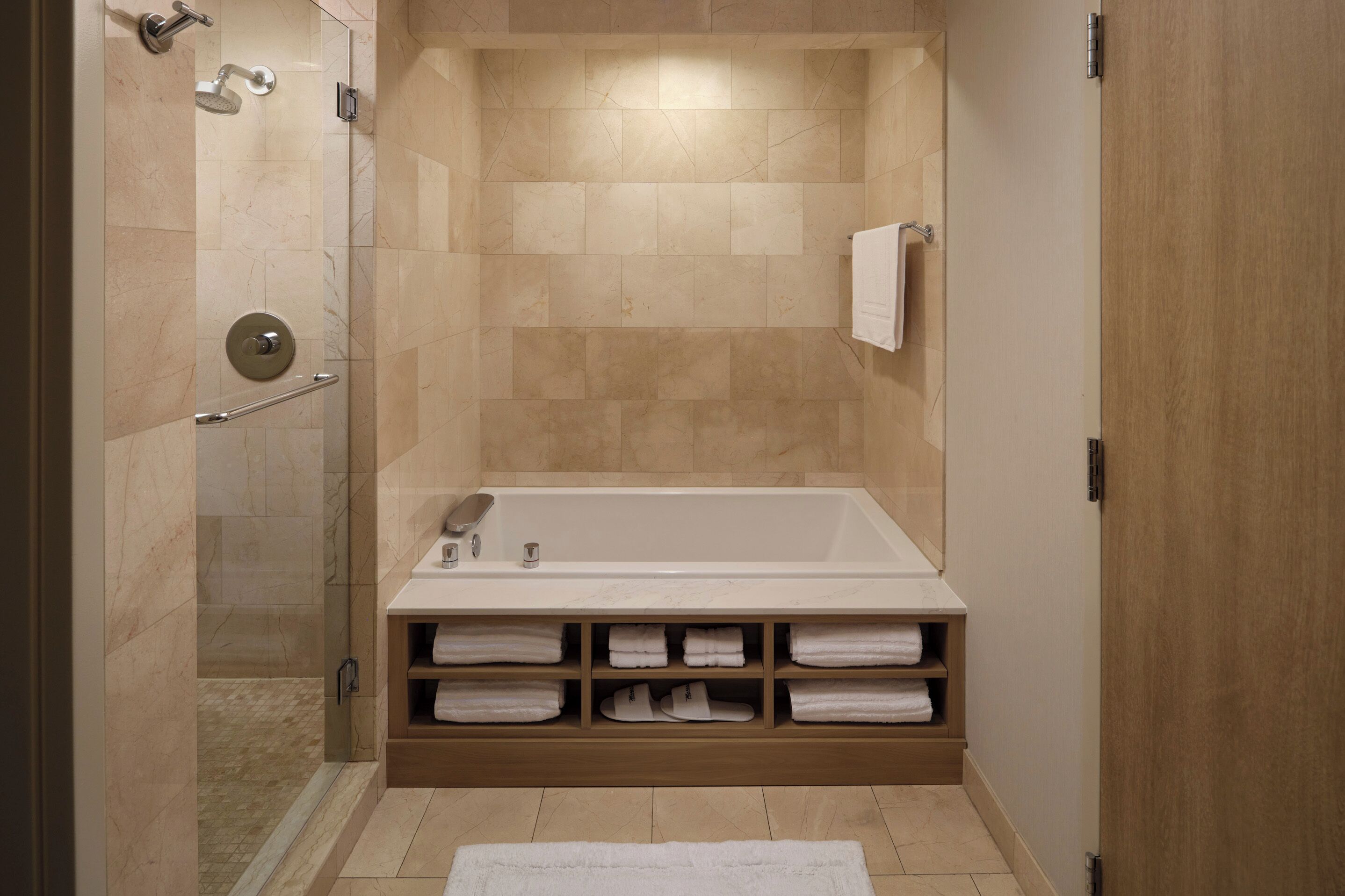 Une salle de bain moderne dotée d’une douche à l’italienne, d’une baignoire sur pieds et d’un porte-serviettes intégré.