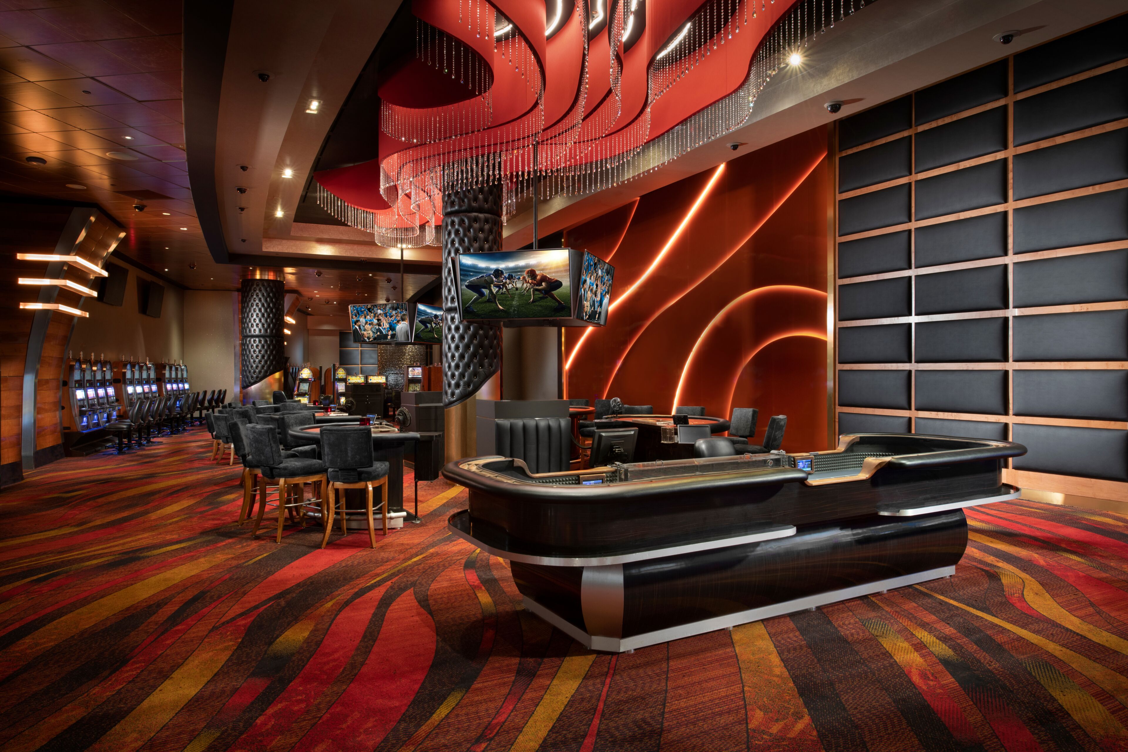 A hotel lobby with a reception desk, seating area, and slot machines.