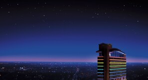Een hoog hotel met een opvallend architectuurontwerp, met een gebogen bovenkant en meerdere verlichte verdiepingen.