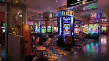 A casino floor with slot machines, designated smoking area, and seating areas.
