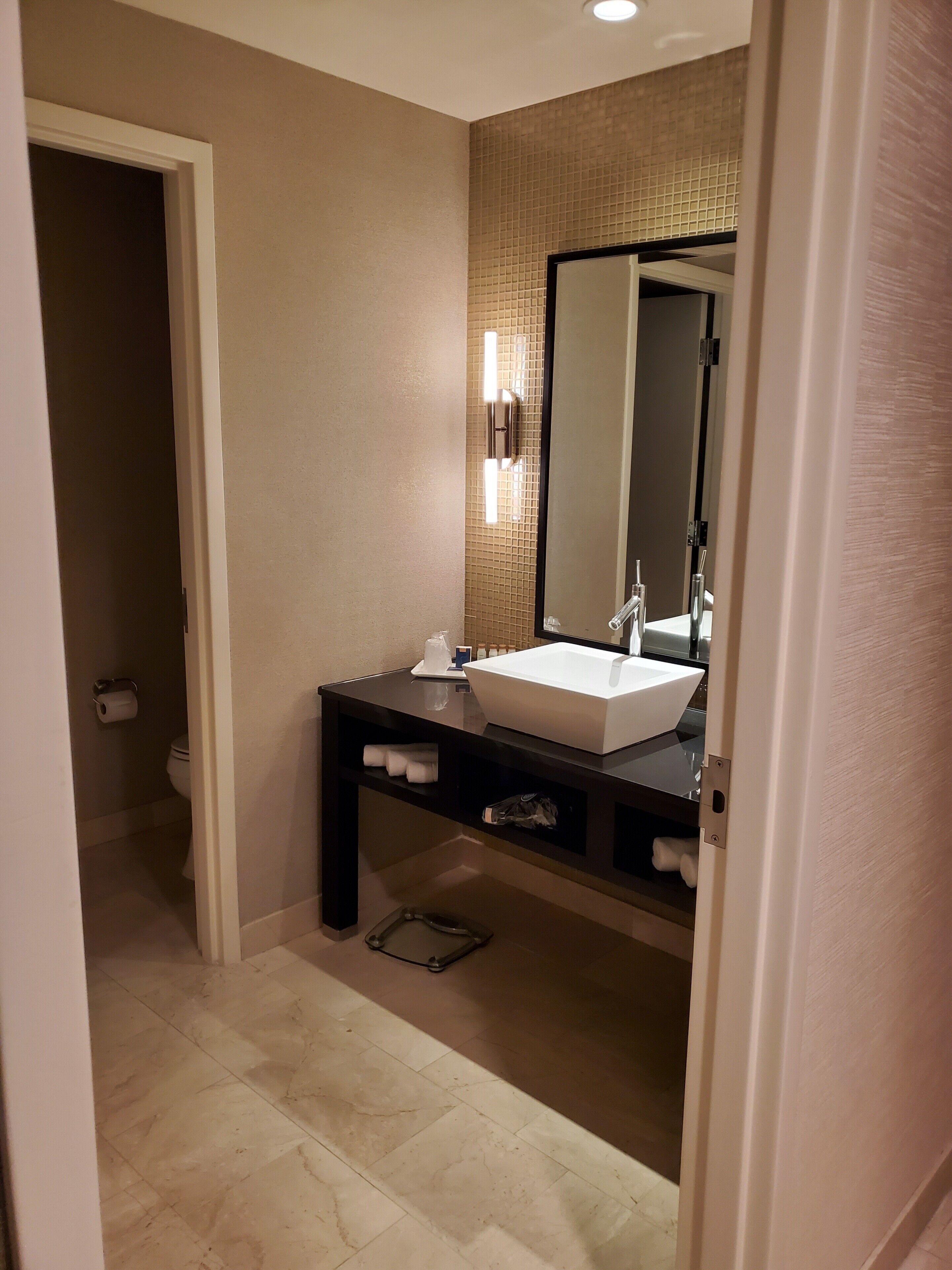 A bathroom with a white sink, a mirror, and a towel rack.