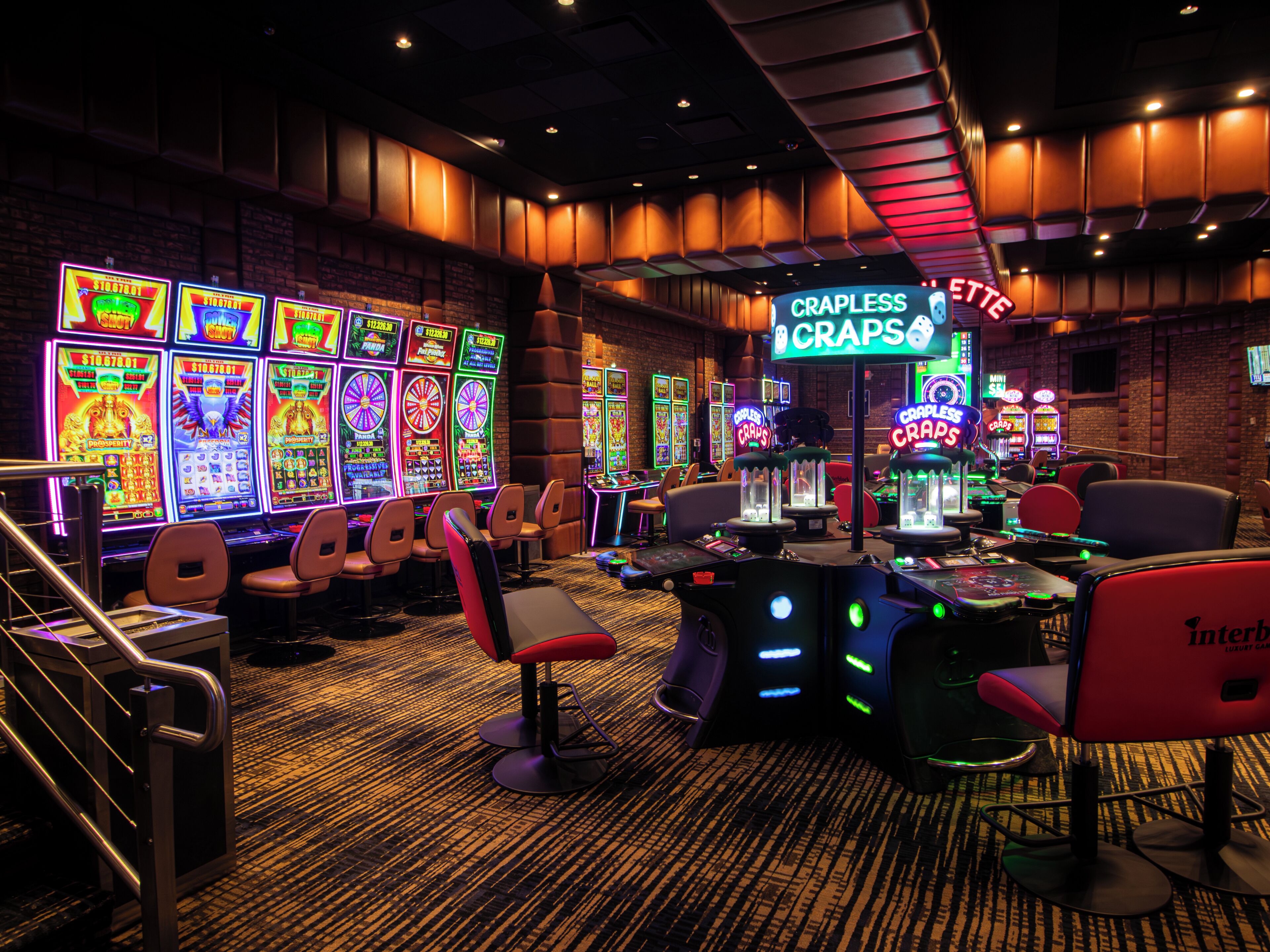 Interior de un casino con máquinas tragamonedas, mesas de juego y zonas de estar cómodas.