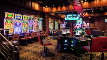 A casino interior with slot machines, gaming tables, and comfortable seating areas.