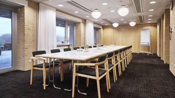 A conference room with a long table, chairs, and a whiteboard.