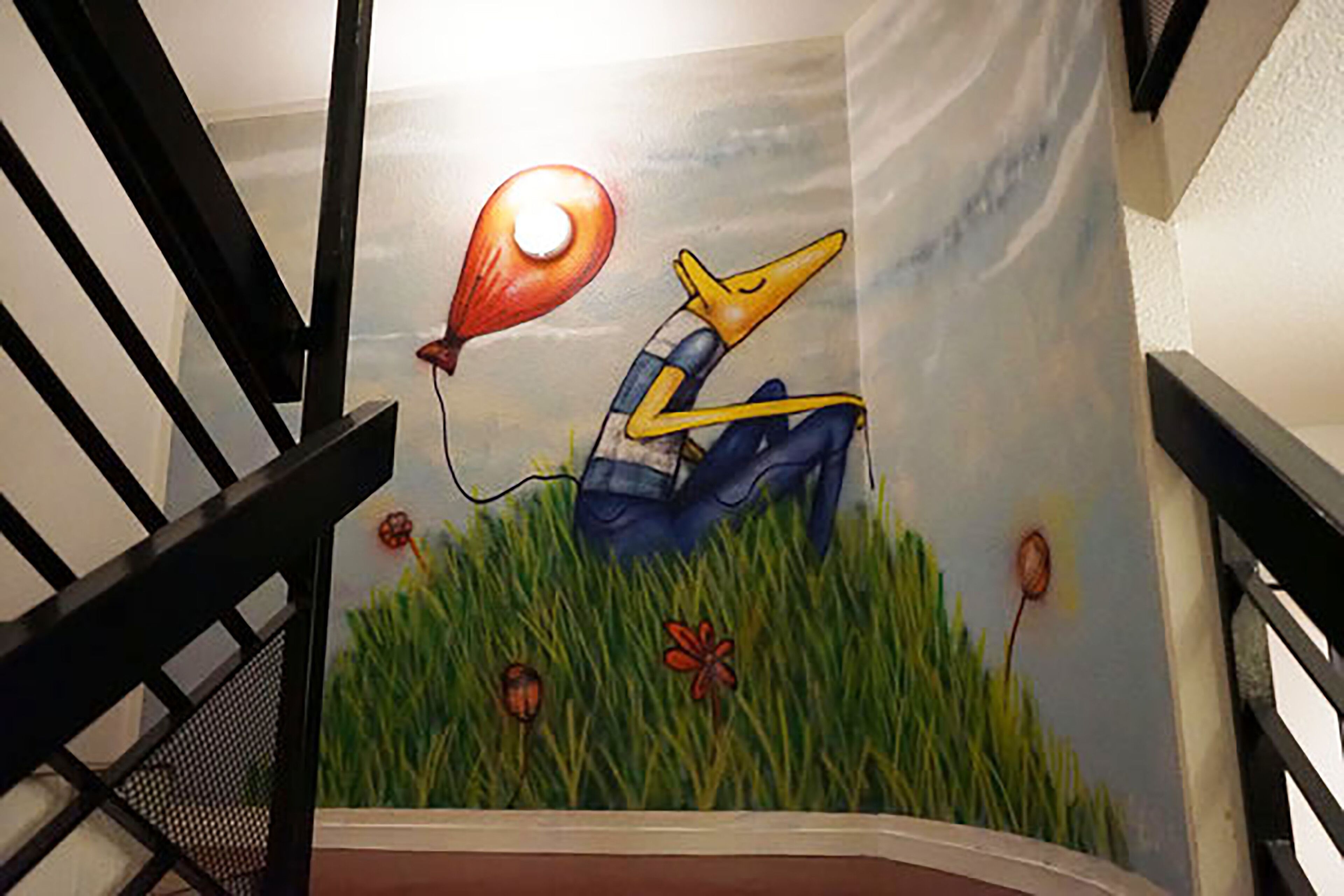 A mural of a bird with a hot air balloon on a staircase.