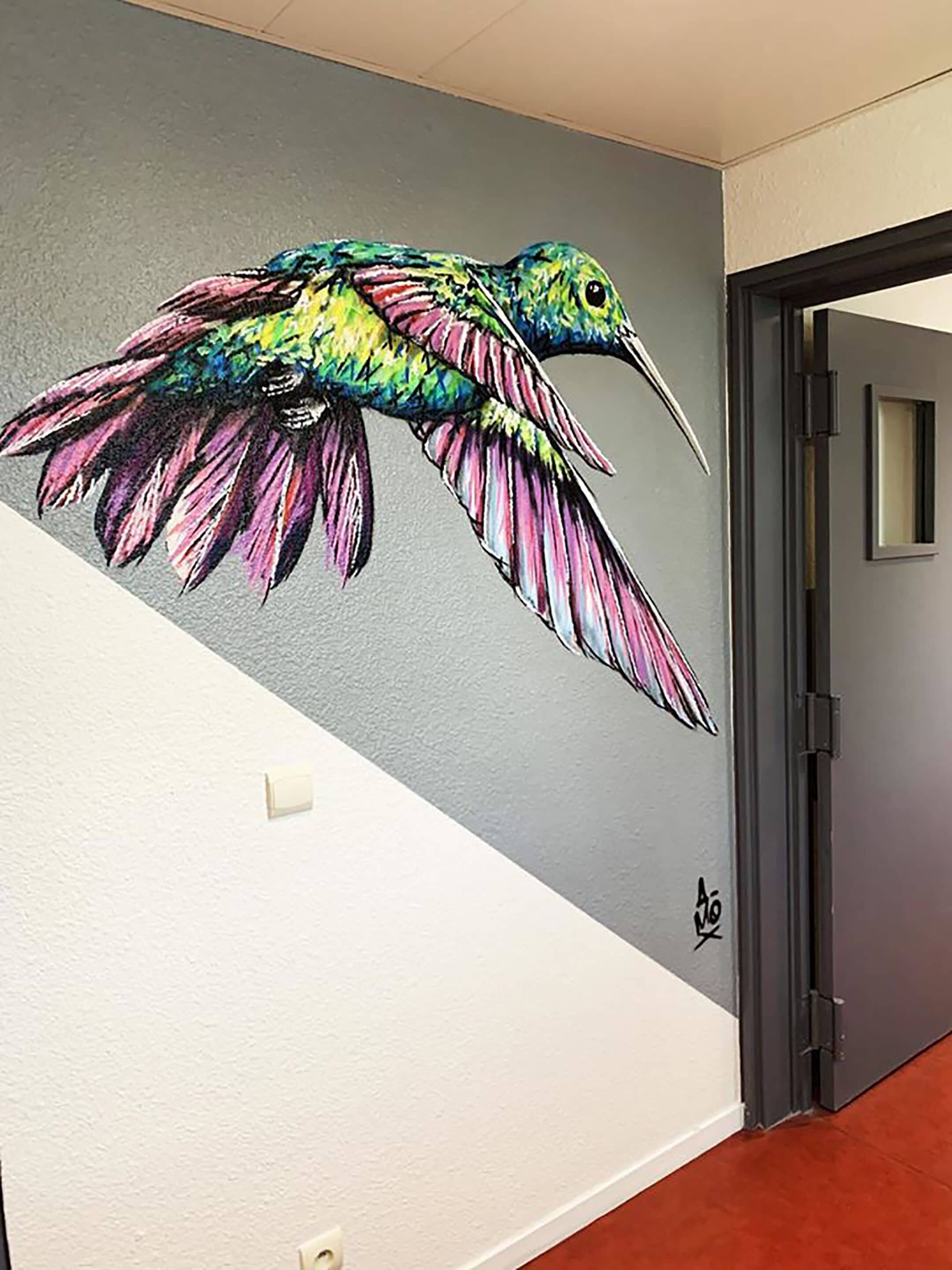 En väggmålning som föreställer en färgstark kolibri.