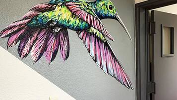 En väggmålning som föreställer en färgstark kolibri.