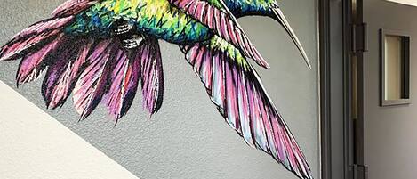 Un mural de un colibrí colorido en una pared.